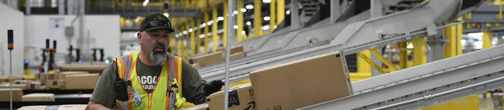 Amazon employee moving boxes fulfilment center